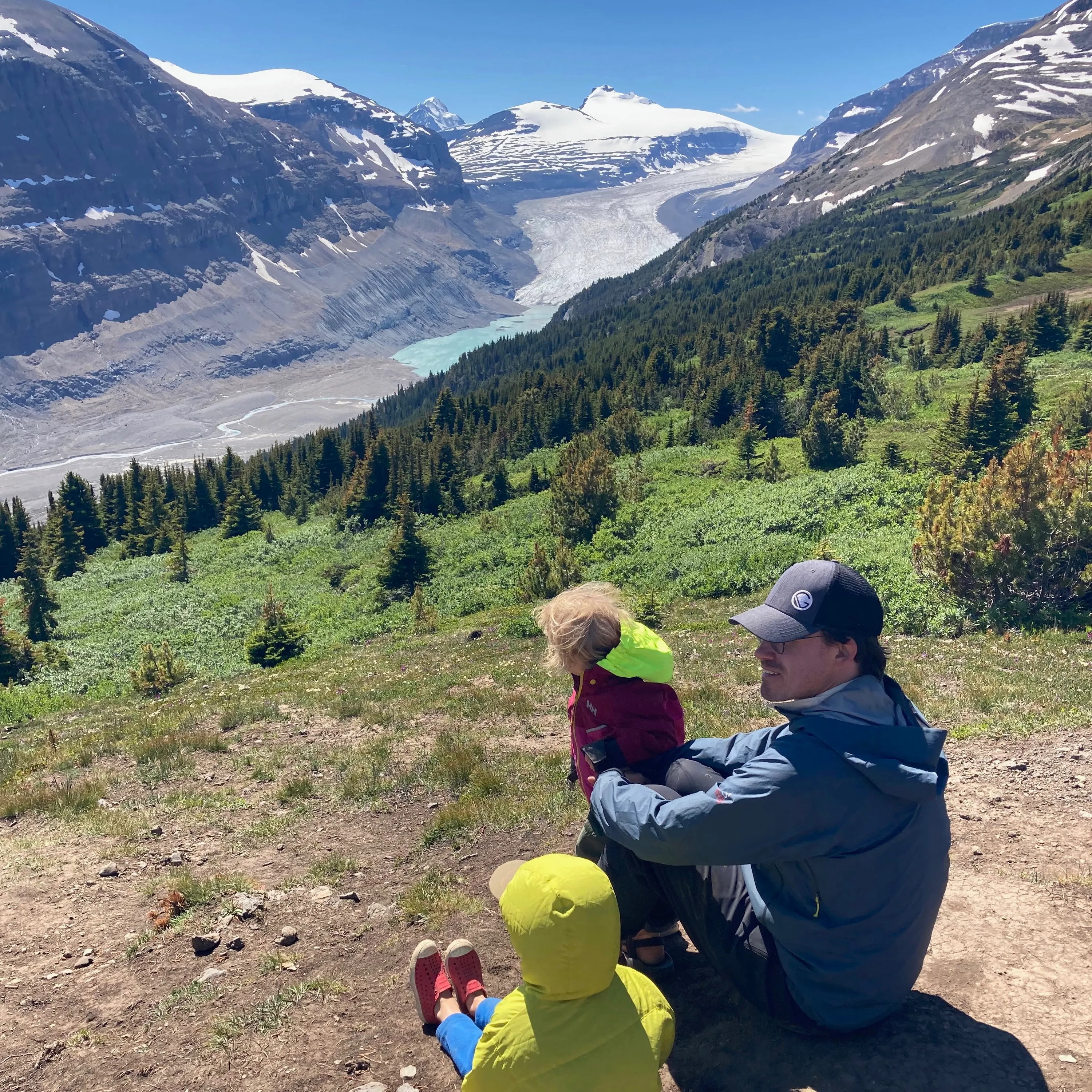 Me sitting looking at a panaromic mountain vista with a glacier in the background